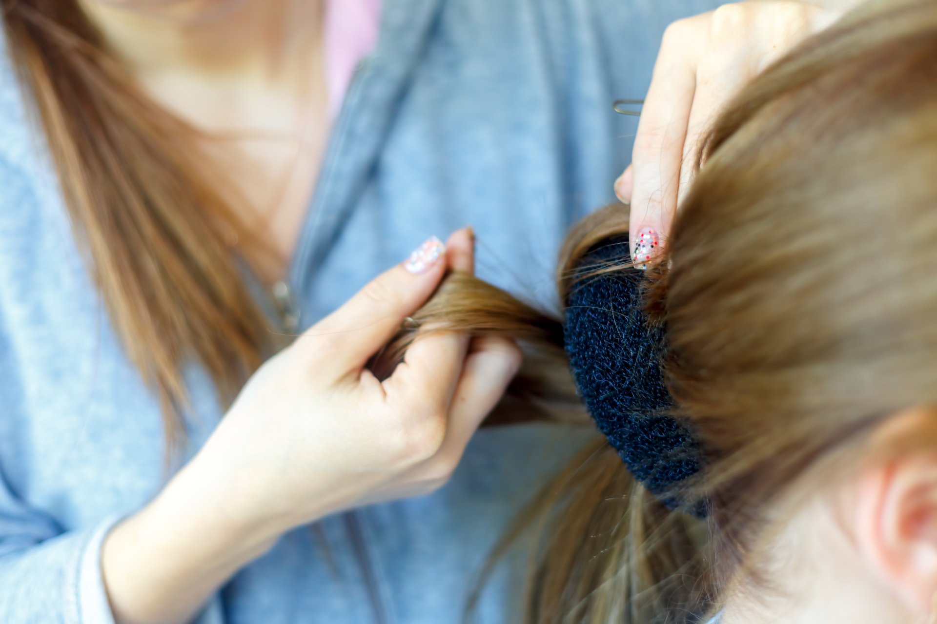 Centro de Peluquería y Estética Gina Bort, especialistas en Peinados Regionales para Fiestas en Borriol. Peluquera realizando peinado regional.